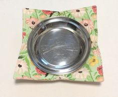 a metal bowl sitting on top of a flowered napkin