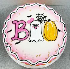 a decorated birthday cake with the letter b on it's side and an image of a ghost