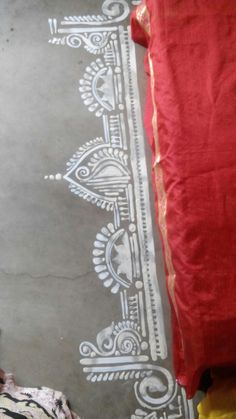 a red cloth is laying on the floor next to a white and black wallpaper