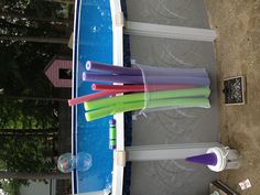 there are many different colored toothbrushes in the cup next to the swimming pool