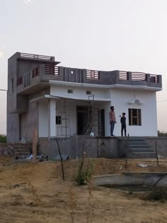 two men are standing on the roof of a house