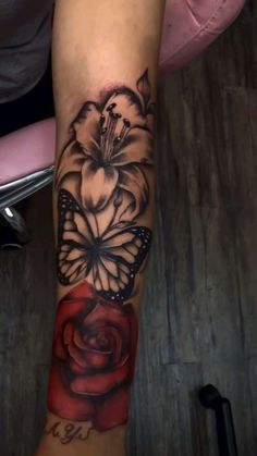 a woman's leg with a tattoo on it that has a rose and butterfly on it