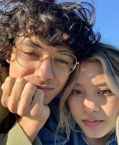 a man and woman are posing for a photo together in front of the blue sky