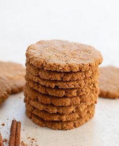 a stack of cookies with cinnamon sticks next to it