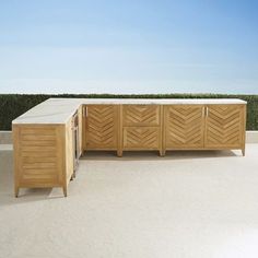 a large wooden cabinet sitting on top of a white floor next to a planter