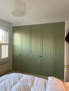 a bedroom with green closets and white bedding in it's center area