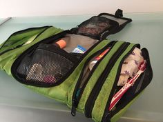 an open backpack sitting on top of a counter next to a knife and toothbrush