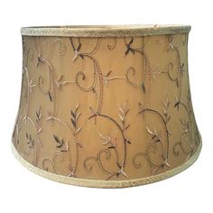 a beige lamp shade with vines and leaves on it