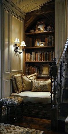 a living room filled with lots of books on top of a book shelf next to a stair case