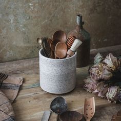 spoons and other kitchen utensils in a cup on a table