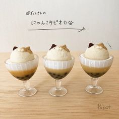 three desserts in small glasses on top of a wooden table with writing above them