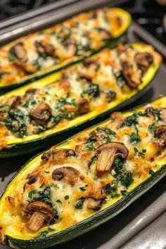 two zucchini boats with mushrooms and spinach on them sitting on a stove