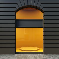 an open window on the side of a building with yellow light coming in from it