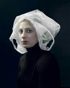 a painting of a woman wearing a white turban over her head and looking at the camera