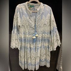 Gorgeous Light Blue And Ivory Dress/Tunic. New With Tags. Never Worn. Bought In A Small Boutique For $153.00. It Is 34 Inches From Shoulder To Hem. The Waist Is 18 Inches Across The Front. It Is A Free Flowing Style With Beautiful Bell Sleeves. Beaded White Embroidery On Each Lapel. Front Tie With Pom-Pom Detailing. Can Be Worn As A Dress, A Tunic Over Jeans Or Leggings Or Even As A Cover-Up. Light Blue Chikankari Embroidery Dress, Cotton Tunic Dress With Lace Trim, Light Blue Bohemian Dress With Lace Trim, Blue Bohemian Dress With Chikankari Embroidery, Blue Bohemian Chikankari Embroidered Dress, Bohemian Blue Chikankari Embroidered Dress, Blue Embroidered Tunic Dress For Spring, Long Sleeve Dresses With Chikankari Embroidery For Vacation, Long Sleeve Chikankari Embroidery Vacation Dresses