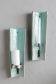 two wall sconces with candle holders on them