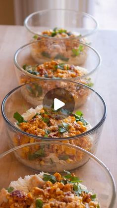 three glass bowls filled with food sitting on top of a table