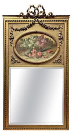 an ornate mirror with flowers painted on the side and gold trimmings around it