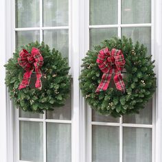 two wreaths with red and green bows on them