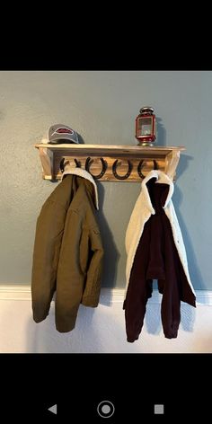 two coats are hanging on a coat rack