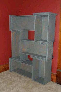 an empty room with red walls and grey shelves on the wall, in front of a carpeted floor