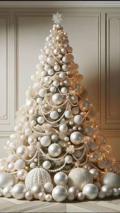 a white christmas tree with ornaments around it