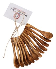 a bunch of wooden spoons hanging from a string with a white tag on it