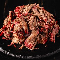 shredded meat sitting on top of a black plate