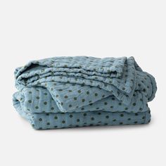 the blue polka dot blanket is folded on top of each other