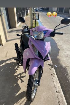 a purple motorcycle parked on the side of a street next to a sidewalk with two smiley faces balloons