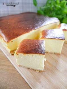 two pieces of cheesecake sitting on top of a wooden cutting board