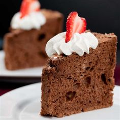 two slices of chocolate cake with whipped cream and strawberries on top