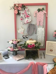 a table topped with baby clothes and flowers