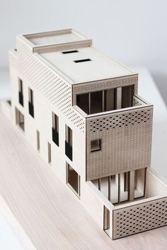 a model of a house on top of a wooden table