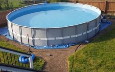 an above ground swimming pool is being constructed in a backyard with grass and fence around it