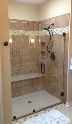 a walk in shower sitting inside of a bathroom next to a wall mounted light fixture