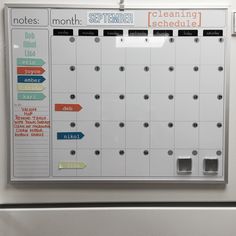 a white board mounted to the side of a wall with magnets and notes on it