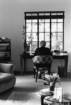 a person sitting at a desk in front of a window