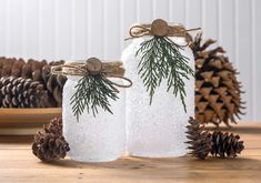 two mason jars decorated with pine cones and twine