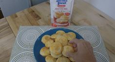 a blue plate topped with biscuits next to a carton of milk