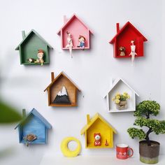 there are many birdhouses on the wall with little figurines in each one