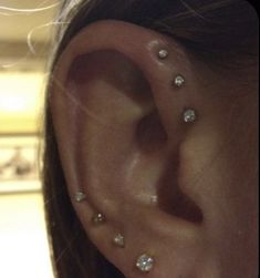 a close up of a person's ear with three different piercings on it