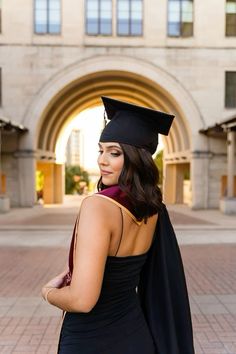 a woman in a graduation gown and cap looking off to the side with her hand on her hip