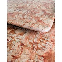 an orange and white marble table top with brown veining on the edges, in close up