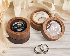 two wooden rings are sitting next to each other on a table with flowers and ribbons