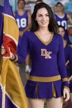 a woman in a cheer uniform holding a flag