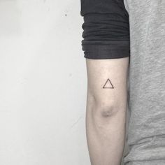 a person with a small triangle tattoo on their arm