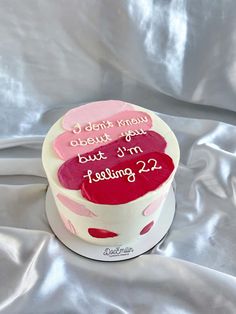 a white cake with pink and red frosting on it