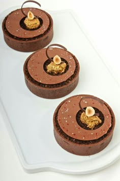 three chocolate desserts on a white platter