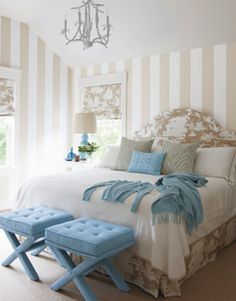 a bedroom with striped walls and blue accents